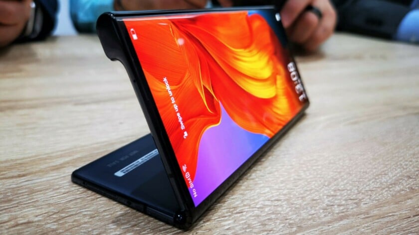 The Huawei Mate X partially folded on a wooden table.