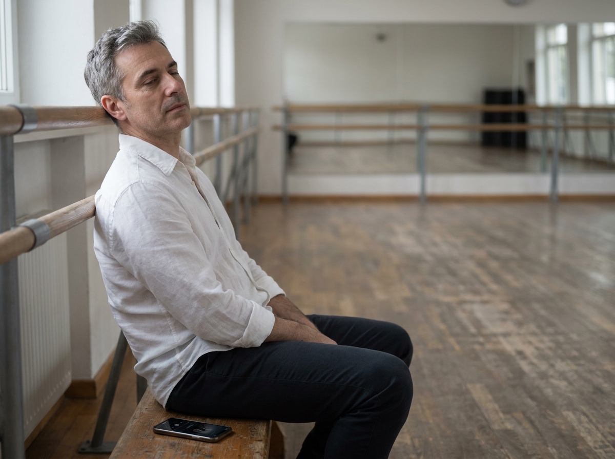 Homme d'une quarantaine d'ann&eacute;es assis en bord de studio de danse, d&eacute;tendu, absorb&eacute; par la musique, illustrant le l&acirc;cher-prise