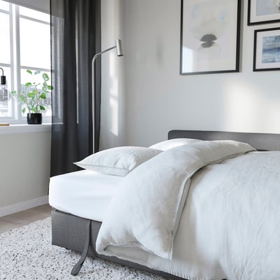 Canapé convertible IKEA dans un salon, préparé en couchage d’appoint
