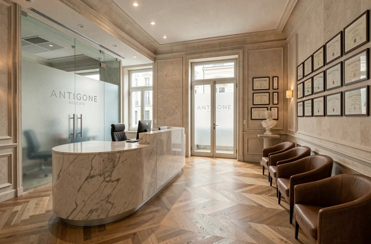 R&eacute;ception moderne du cabinet Antigone Avocats &agrave; Nantes avec comptoir en marbre et fauteuils en cuir